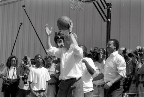 Clinton playing basketball with youth.