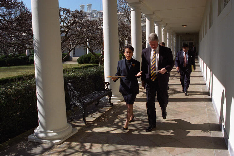 President Clinton walks with Alexis Herman along a colonnade