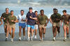 Jogging with Navy Seals President Clinton jogs on the sand. He wears a Navy blue shirt, blue shorts, and a blue cap. Five Navy Seals are pictured running with the President.