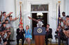 AmeriCorps Event AmeriCorps Volunteers Stand with arms raised towards President Clinton and the First Lady.