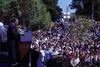 Ernest Green stands on a stage, behind a podium, looking out toward a crowd of people