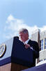 President Clinton stands behind a podium looking down at his speech.