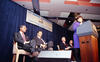 Sec. Alexis Herman at the podium a. Seated behind Herman are, President Clinton; Rev. Jesse Jackson; and Chairman of the New York Stock Exchange, Richard Grasso. 