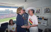 In the foreground, Hillary Rodham Clinton (left), then-First Lady of the United States, stands in a dark blue dress while shaking hands and speaking with Ximena Iturralde (right), then-First Lady of Bolivia. Iturralde wears a white t-shirt featuring the word "BOLIVIA" and a colorful map above the WorldCupUSA94 logo, topped by a wide-brimmed white hat.