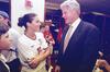 A photograph shows Bill Clinton smiling and speaking with U.S. soccer player Julie Foudy, who is wearing her white number 11 jersey, inside a locker room after a FIFA Women's World Cup match.