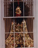deocorated White House Christmas Tree lit by tree lights. The photograph taken through a paned window from outside of the White House. Curtains and a green wreath and read bow can also be seen in the photograph.