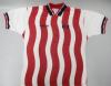A short-sleeved soccer jersey featuring vertical red and white wavy stripes on the torso is laid flat against a light grey background. The sleeves are solid white and finished with dark blue and red striped cuffs. The jersey has a dark blue collar with a red and white inner V-neck trim. On the right chest, the Adidas logo is embroidered in dark blue, while a stylized "US" logo is embroidered on the left chest.