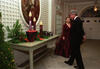 President Clinton and First Lady Hillary Rodham Clinton view Christmas decorations in the White House. They are dressed in formal attire. They look at a long table decorated with three candles.