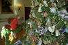 First Lady Hillary Rodham Clinton bends at the waist toward the White House Christmas Tree. The First Lady wears a red jacket and red skirt.