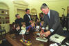 President Clinton places a menorah on the resolute desk in the Oval Office. President Clinton wears a yarmulka. Children lean over desk.