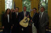 President Clinton takes a photograph with the band, the Eagles in the Oval Office. The band presents the President with a guitar