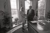 Black and white photograph. President Clinton meets with Stephanie Streett in the White House Oval Office. Both stand next to the windows in the Oval Office.