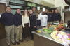 Camp David Kitchen President Clinton, Hillary Rodham Clinton, and Chelsea Clinton pose for a photograph with the kitchen staff in the kitchen at Camp David. 11 people are picture in the photograph including the First Family. Two men can be seen wearing tall white chef's hats.