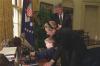 Radio Address President Clinton and First Lady Hillary Rodham Clinton show photos and other items in the Oval Office to Brendon Denny who was injured in the bombing of the Murrah Federal Building in Oklahoma City. They Denny family were guests at the President's Radio Address