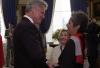 President Clinton greets singer-musician Joan Baez in a receiving line in the Blue Room of the White House during the Medal of Freedom awards
