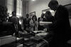 Black and white photograph. President Clinton sits at a desk, others are standing.