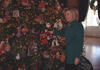 First Lady Hillary Rodham Clinton stands and holds a Christmas tree ornament on a decorated Christmas tree.