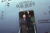 President Clinton, and First Lady Hillary Rodham Clinton wave from the doorway of "The Spirit of Bob Hope" airplane in Sarajevo, Bosnia-Herzegovina