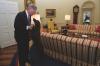President Clinton plays with Buddy the Dog in the Oval Office. President Clinton holds Buddy's paws and Buddy stands on his hind legs. The President wears glasses and appears to be speaking to Buddy.. 