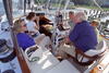 Sailing with Cronkite President Clinton, Hillary Rodham Clinton, and Chelsea Clinton sail with broadcast journalist, Walter Cronkite, on Cronkite's sailboat. They all sit on the boat. Crokite sits at the helm, steering the boat. A young boy can be seen sitting near Cronkite