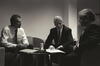 Black and white photograph. President Clinton sits and talks with Prime Minister Tony Blair and Sandy Berger