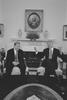 Black and White photograph. President Václav Havel of the Czech Republic sit next to each other in arm chairs in the Oval Office. President Clinton Holds his arms and hands out in a gesture. President Havel looks down, smiling with his hands folded in front of him. Hanging above the mantel is a famous "porthole" portrait of George Washington by artist Rembrandt Peale.