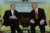 President Clinton and President Václav Havel of the Czech Republic sit on yellow chairs in the Oval Office.