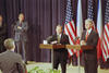 President Clinton and President Václav Havel stand a podiums facing journalists.  Three United States flags and two Czech republic flags are in the background. Two unidentified men can be seen standing behind the presidents (left). A man is standing in front of the Presidents looking toward the Presidents.