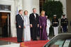 President Clinton, First Lady Hillary Rodham Clinton, President Václav Havel, and Dagmar Havlová stand on a red carpet in front of the White House. Three uniformed military personnel stand at attention in the background.