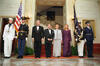 President Clinton, First Lady Hillary Rodham Clinton, President Václav Havel, and Dagmar Havlová stand on a red carpet on a tiled floor. Four uniformed military personnel stand at attention. A United States Flag and the flag of the President stand in the background.