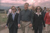 Stenkovic 1 Refugee Camp President Clinton, Hillary Rodham Clinton, and Chelsea Clinton hold hands as they walk along a road at Stenkovic 1 Refugee Camp. A crowd of individuals can be seen walking behind the First Family.
