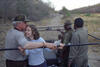 Ranthambhore National Park President Clinton kisses Chelsea Clinton's head while standing in the back of a jeep. They both hold rails in the jeep as they stand. Two other men can bee seen standing in the back of the jeep.