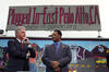 Plugged In Event President Clinton and Rev. Jesse Jackson stand in front of a sign that reads "Plugged In-East Palo Alto, CA." President Clinton holds his hand under his chin. Jackson crosses his hands in front of him.