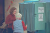 Voting in Cappaqua Chelsea Clinton is assisted by a poll worker outside of a voting machine. The voting machine is aqua in color.