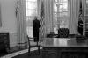 Last Day in Office President Clinton stands alone, looking out of a window in the Oval Office, on his final day as President of the United States,