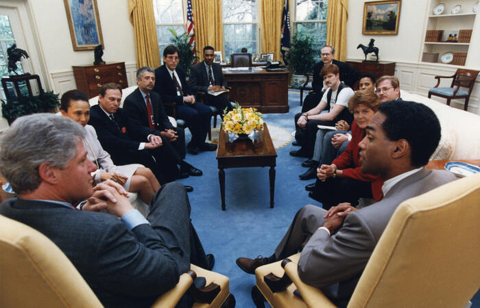 President Clinton meets with gay-rights leaders in the Oval Office. President Clinton sits next to Phill Wilson of the Black Gay and Lesbian Leadership Forum. Also present are Torie Osborn, Tim McFeely, William Weybourn, Thomas Stoddard, Billy Hileman, and Nadine Smith. White House Staff, Alexis Herman and Keith Boykin are also in the Oval Office meeting. 