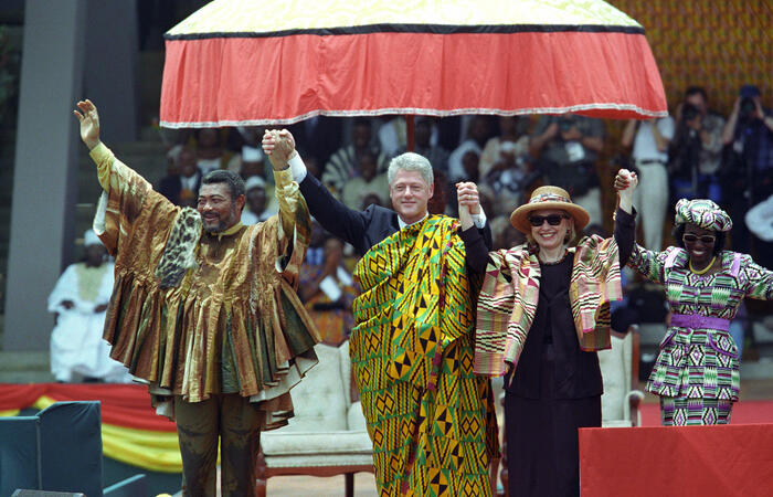 President Clinton, First Lady Hillary Rodham Clinton, President Jerry John Rawlings and his wife Nana Konadu Agyeman Rawlings raise their arms together on the dais in Accra, Ghana