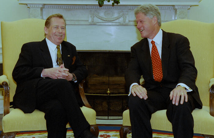 President Clinton and President Václav Havel of the Czech Republic sit on yellow chairs in the Oval Office.