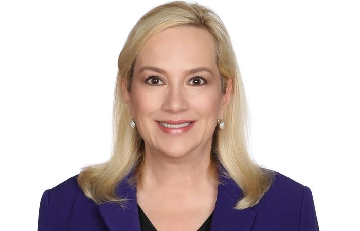 Stephanie Streett headshot. She wears a black top covered with a blue/violet blazer.
