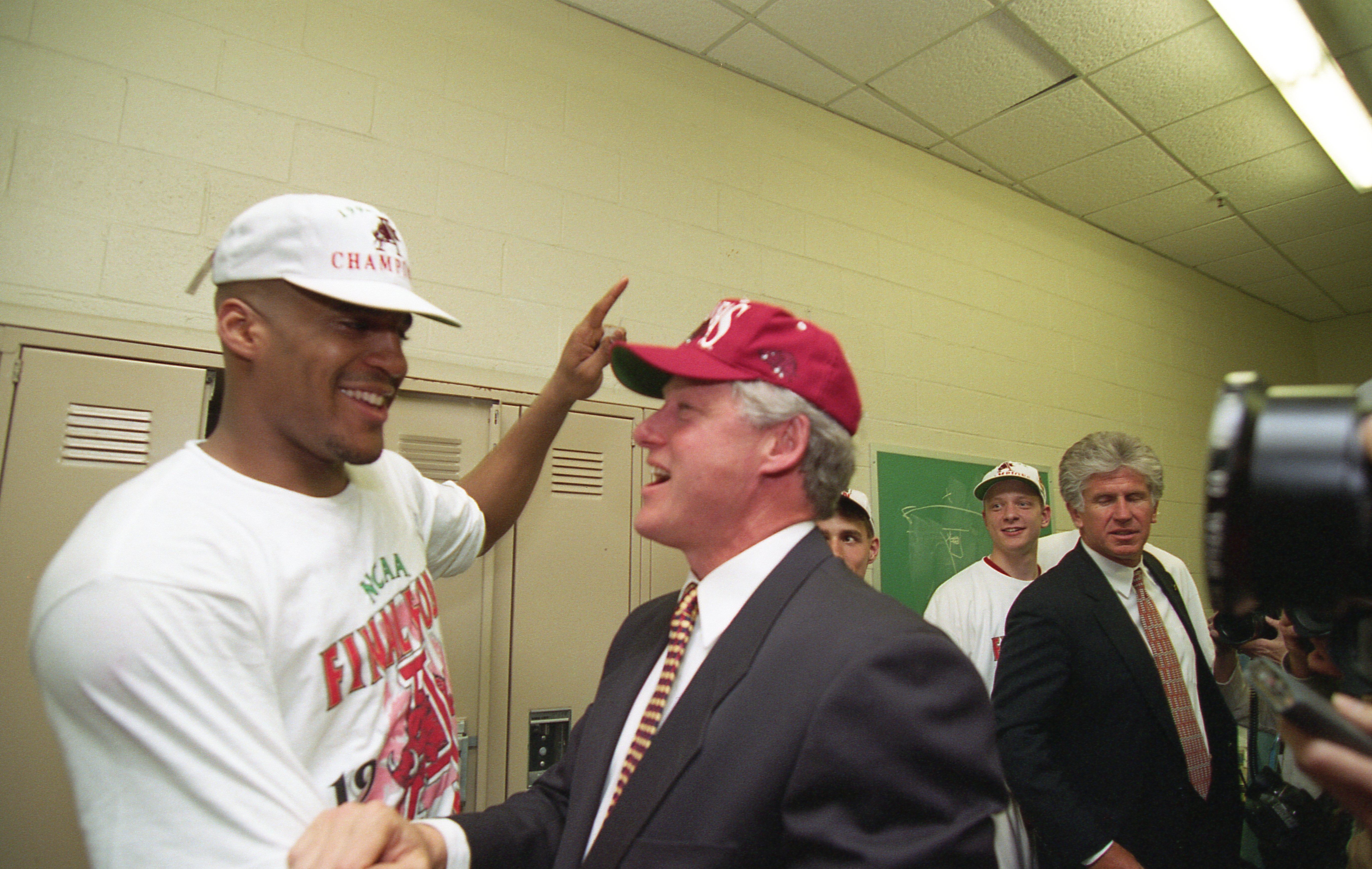 President Clinton congratulates and celebrates with Arkansas Razorback basketball player, Corliss Williamson after the Razorbacks won the 1994 National Championship. Williamson was awarded the Most Valuable Player (MVP). The President wears a red Arkansas razorback shirt.