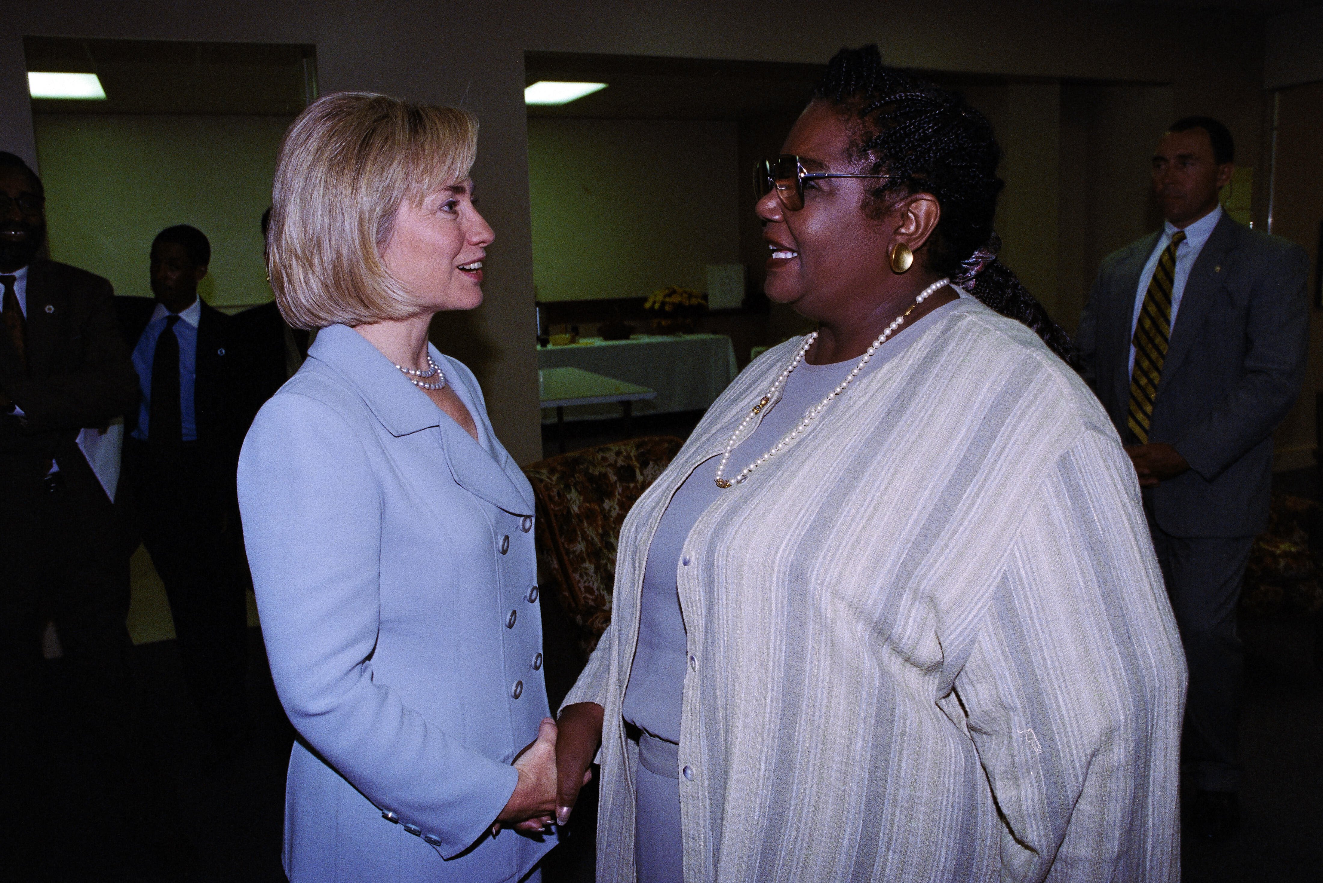 First Lady Hillary Rodham Clinton stands while shaking hands with Little Rock Nine member, Melba Patillo Beals