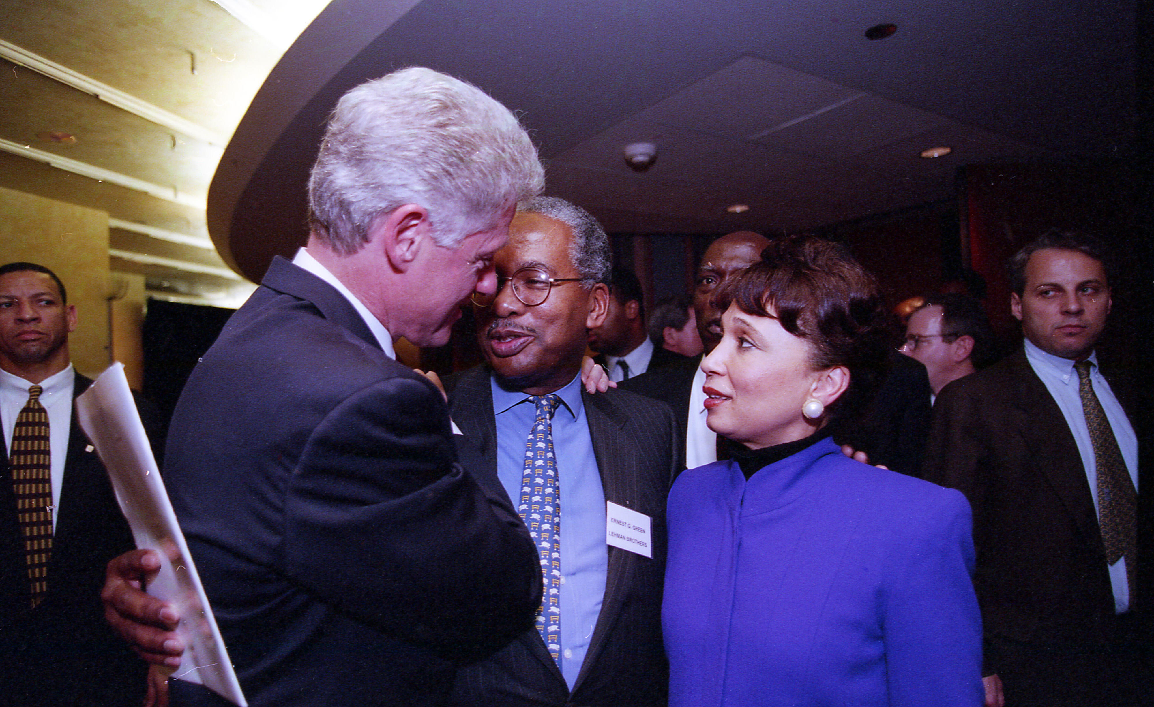 President Clinton stands and visits with Ernest Green and Sec. Alexis Herman