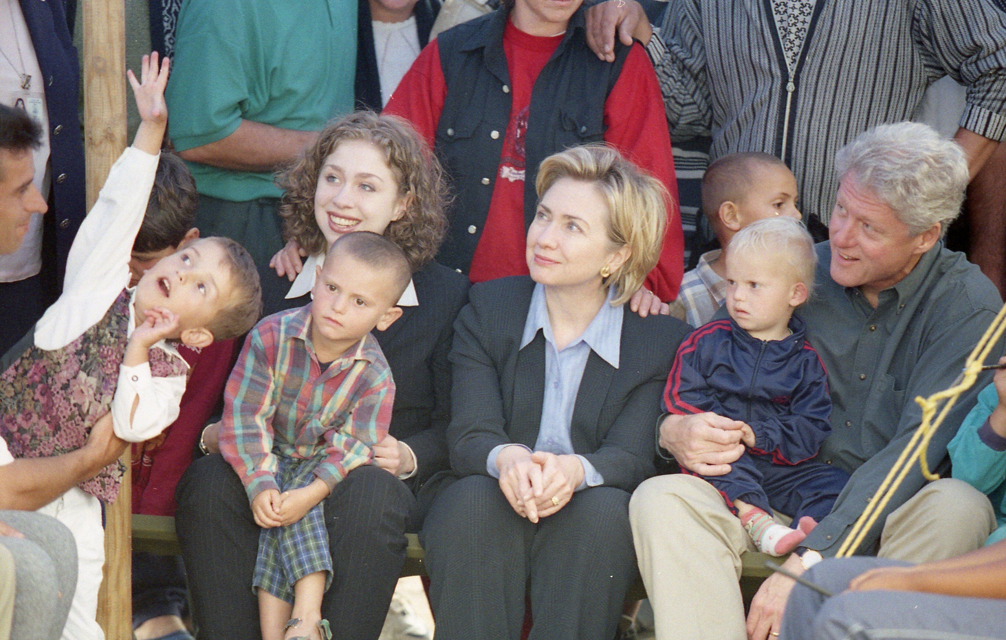 President Clinton, First Lady Hillary Rodham Clinton and Chelsea Clinton sit in a crowd of Kosovar refugee children in Stenkovic 1 Refugee Camp near Skopje, Macedonia