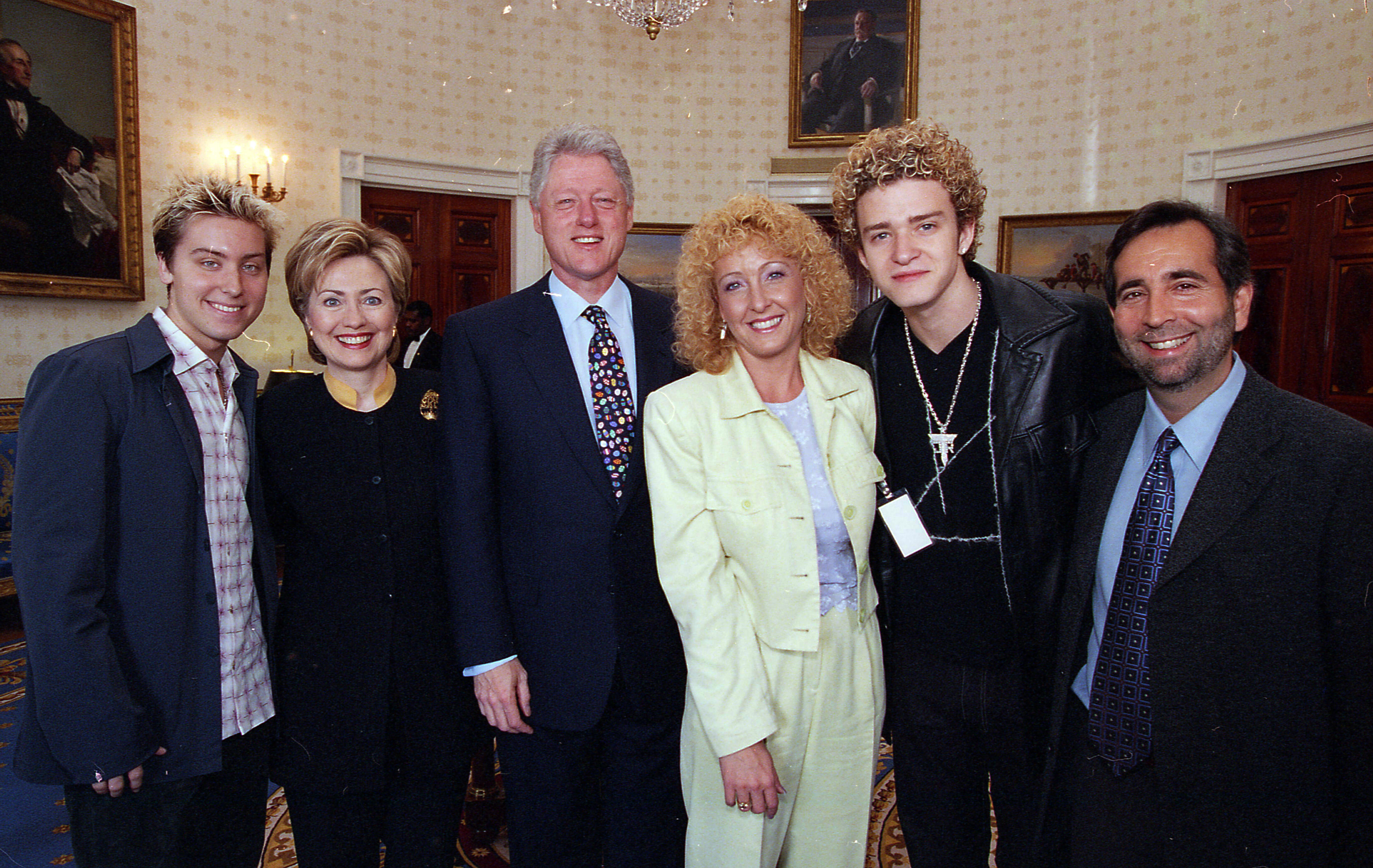 The Clintons pose for a photo at the Easter events reception with singers Justin Timberlake and Lance Bass from the band NSYNC and others in the Blue Room of the White House. 