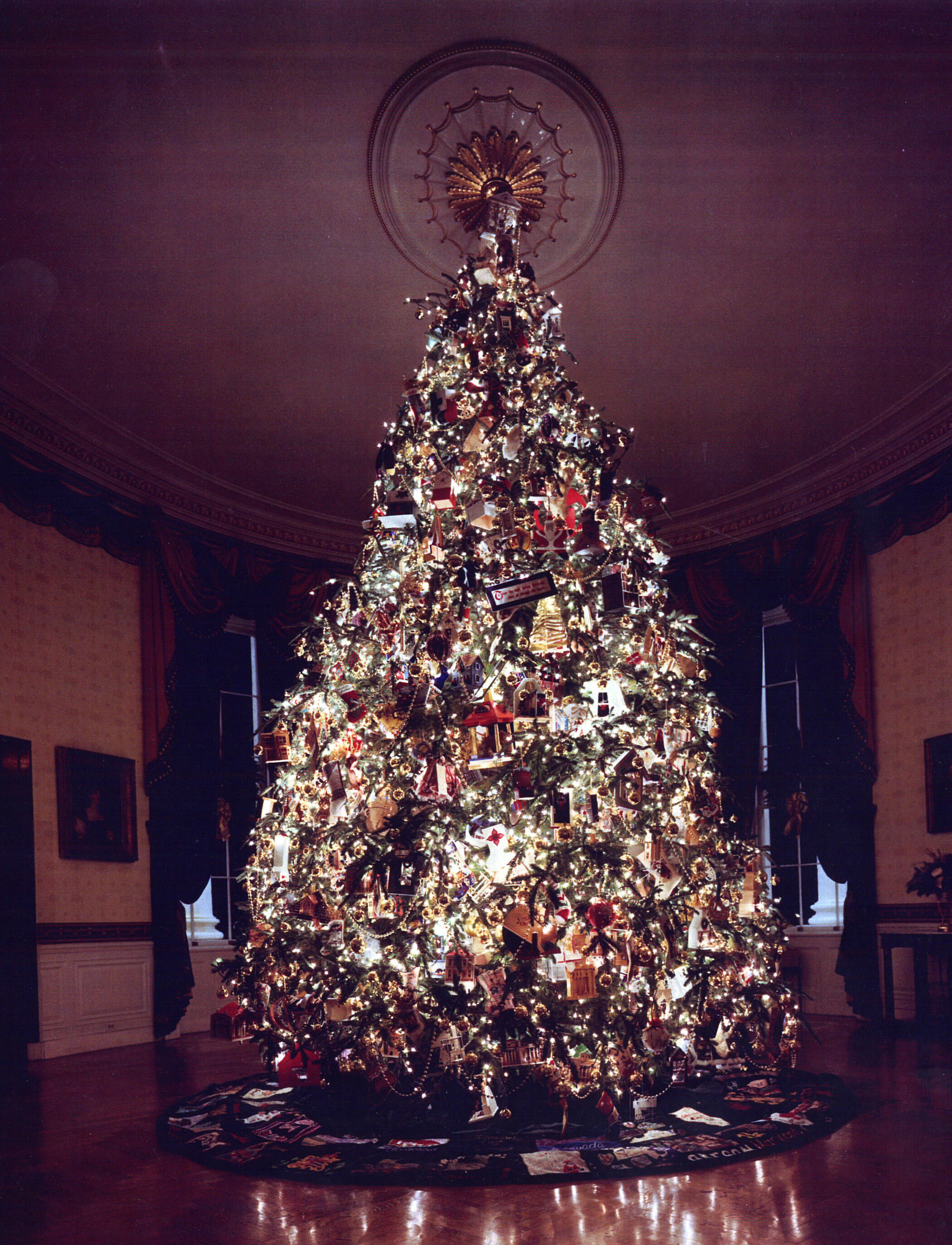 Decorated White House Christmas Tree in a dark Blue Room lit by the light of the tree lights