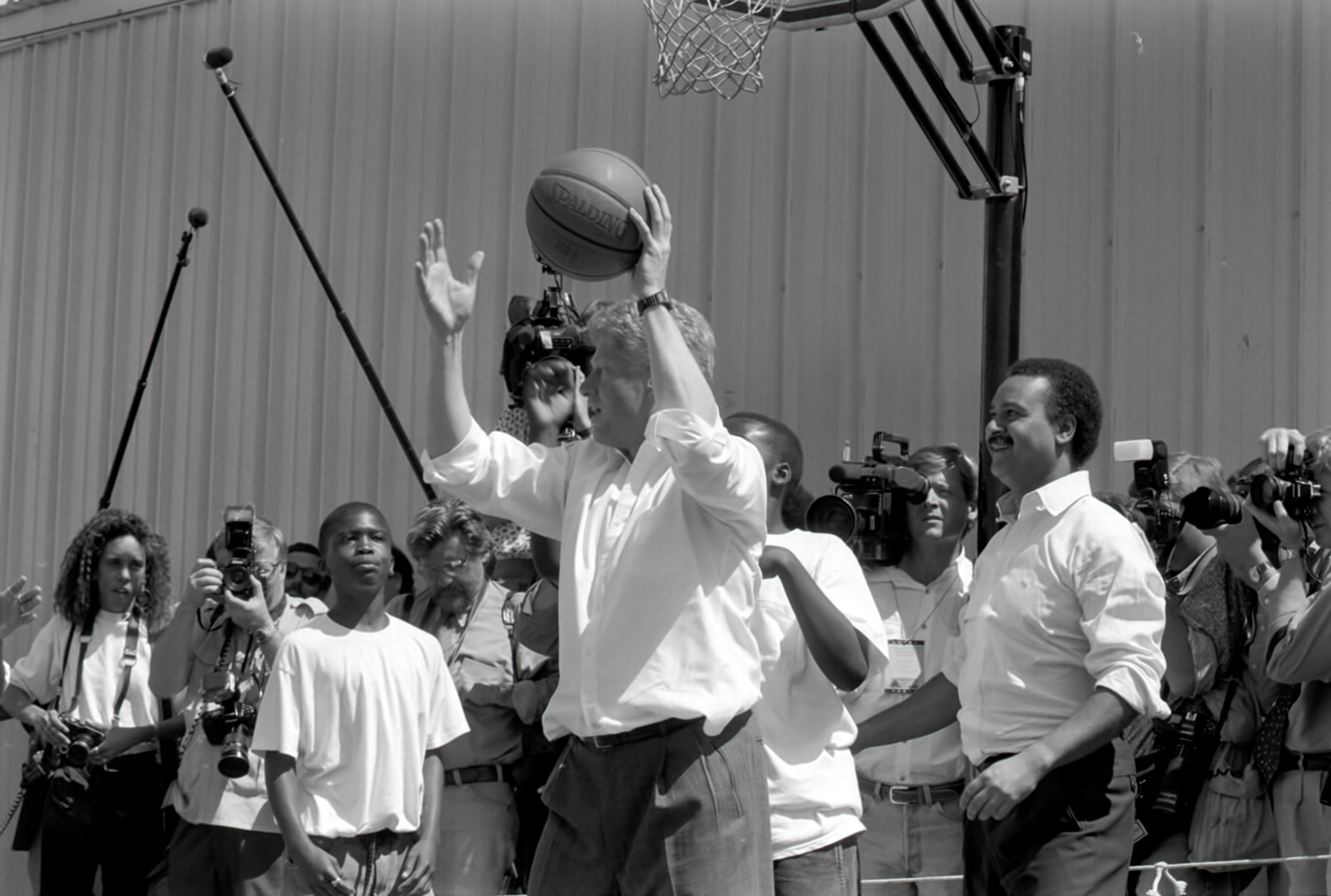 President Bill Clinton plays basketball with Secretary of Commerce Ron Brown and neighborhood boys at "The Playground" basketball court and shoe store