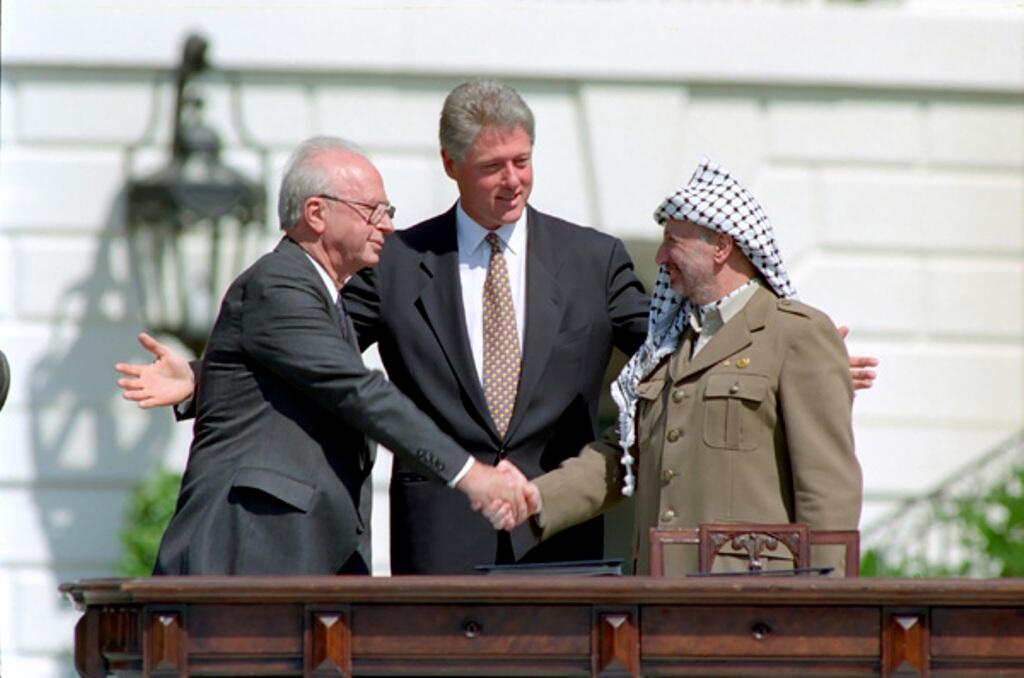 President William J. Clinton presiding over the handshake of Israeli Prime Minister Yitzhak Rabin and Palestinian Liberation Organization (PLO) Chairman Yasser Arafat during the Middle East Peace Agreement signing ceremony. The ceremony was on the South Lawn of the White House