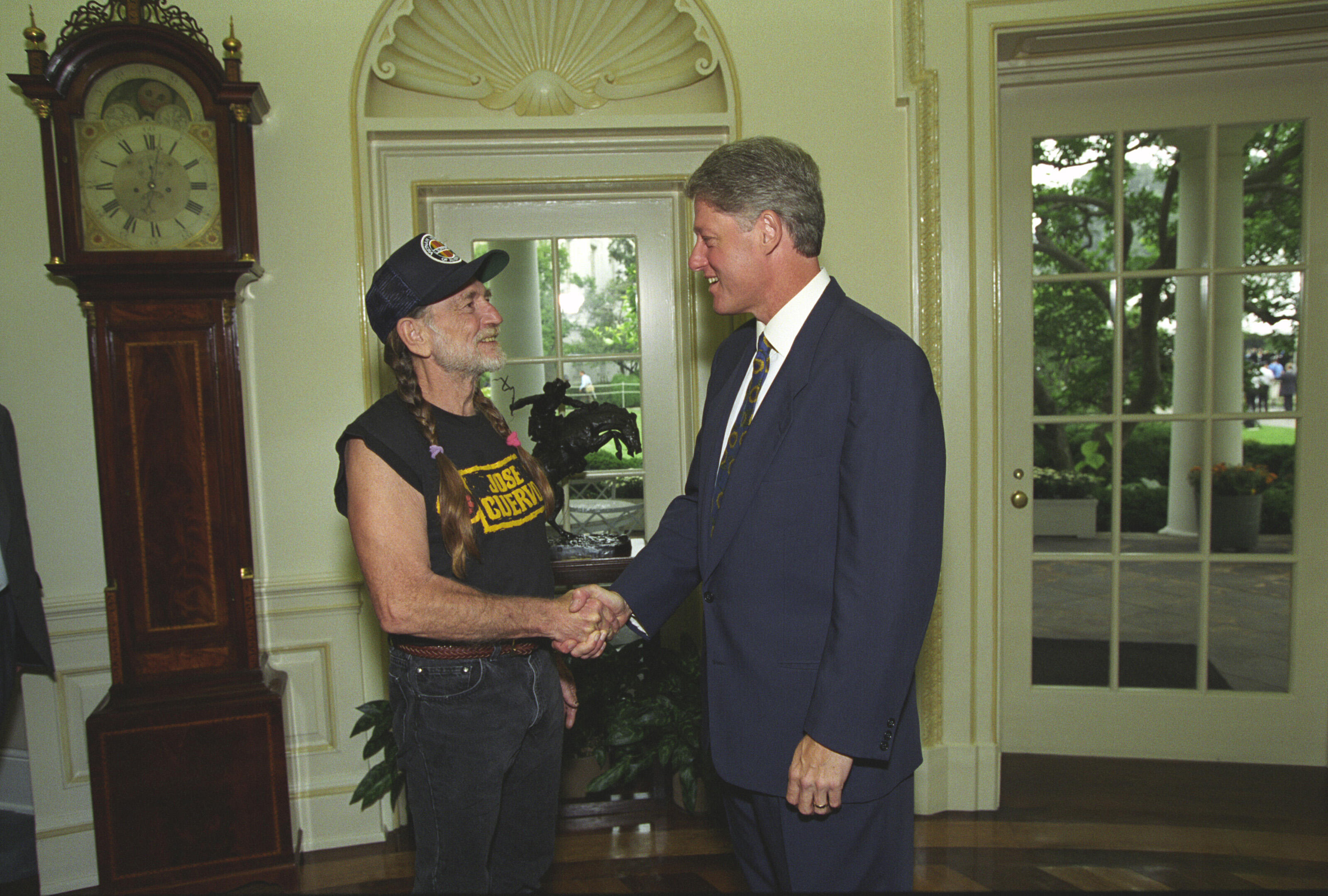 President William J. Clinton greets musician Willie Nelson in the Oval Office of the White House