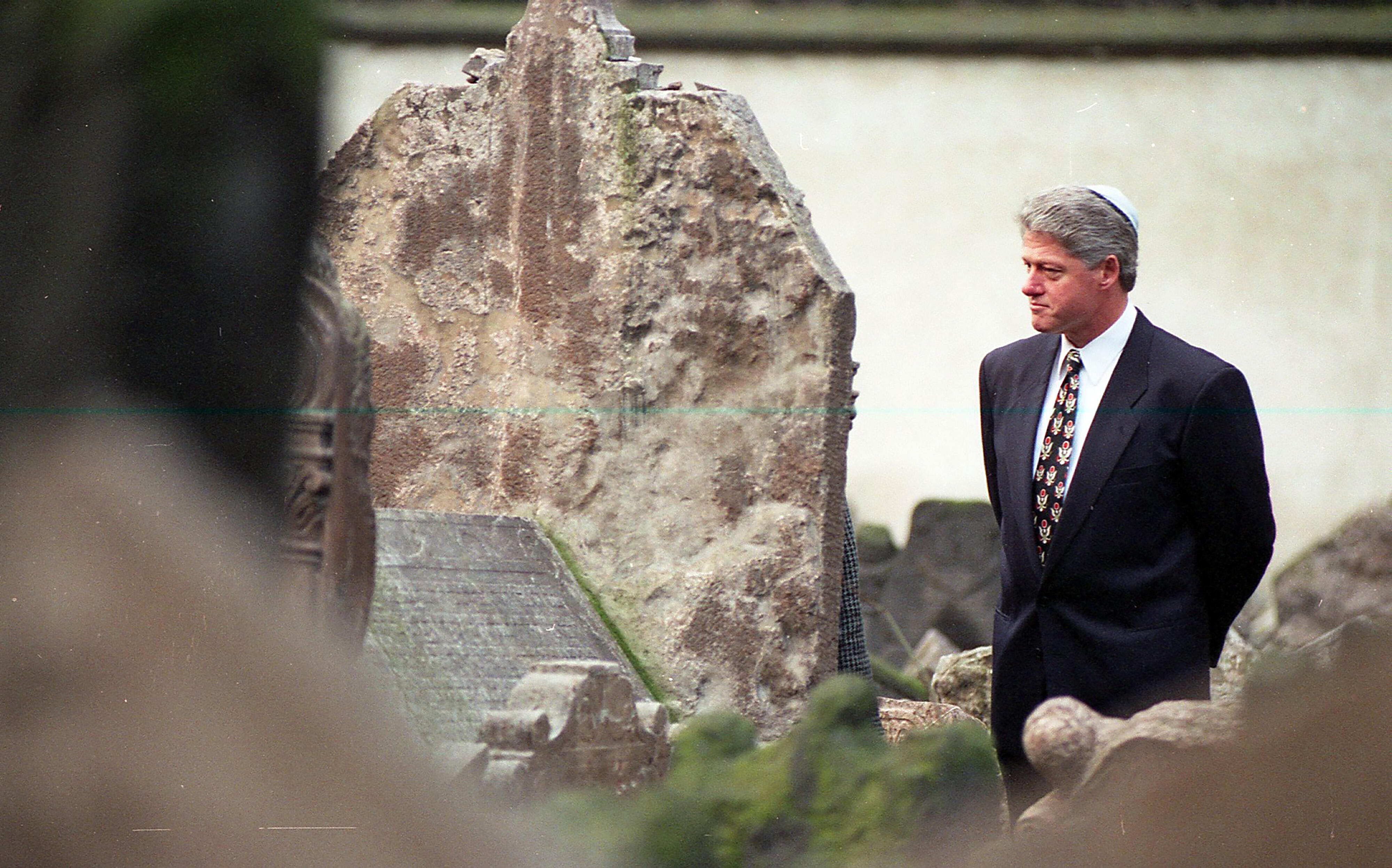 President Clinton visits the historic Old Jewish Cemetery and stands among the graves in Prague. He wears a yarmulke. 