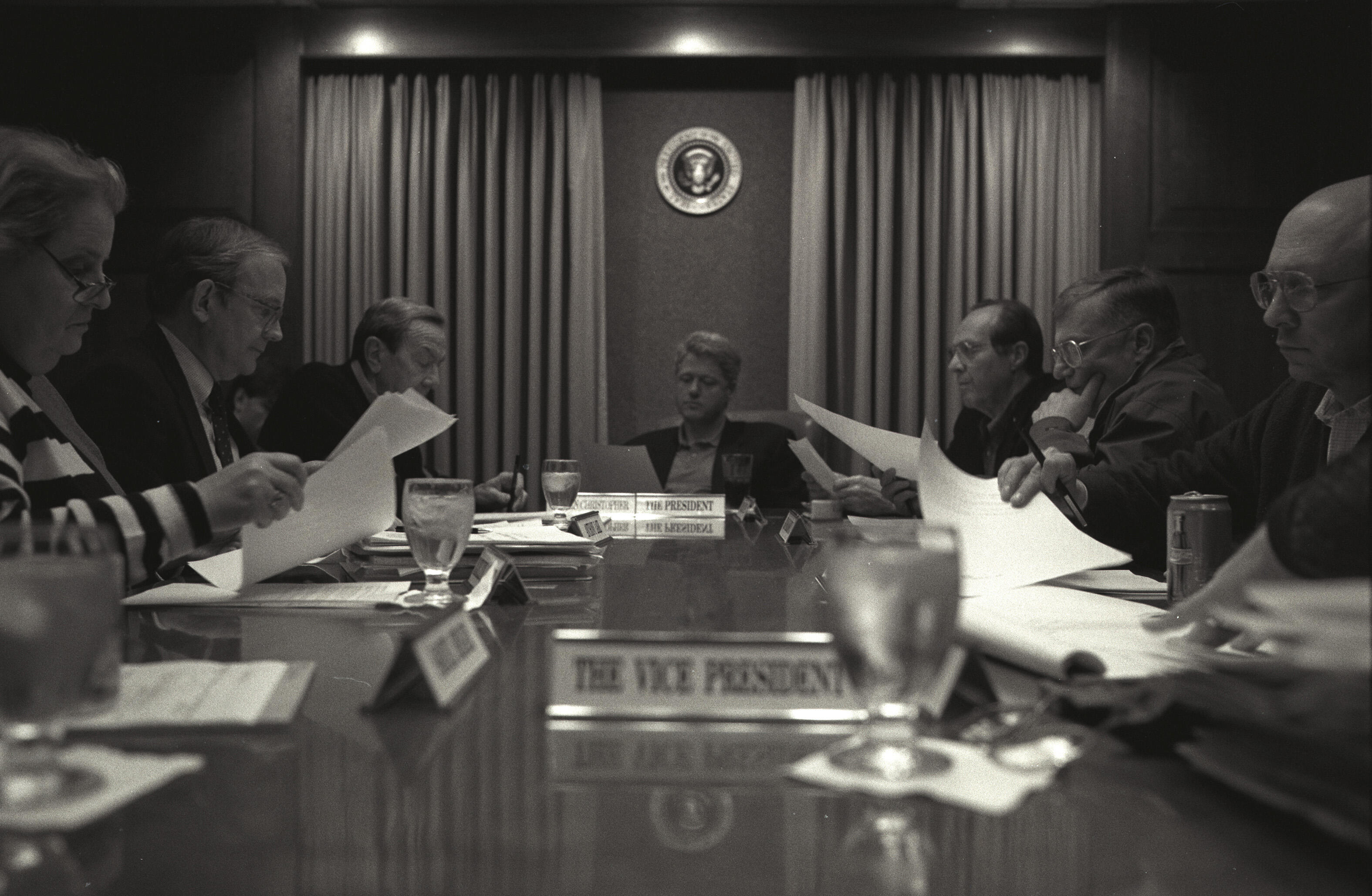 Black and White Photo. Clinton sits at a table with his advisors. President William Jefferson Clinton participating in a meeting on Bosnia in the Situation Room. Participants include Vice President Albert "Al" Gore, Secretary of State Warren Christopher, Tony Lake, William Perry, General John Shalikashvili, James Woolsey, Leon Fureth, and David Gergen.